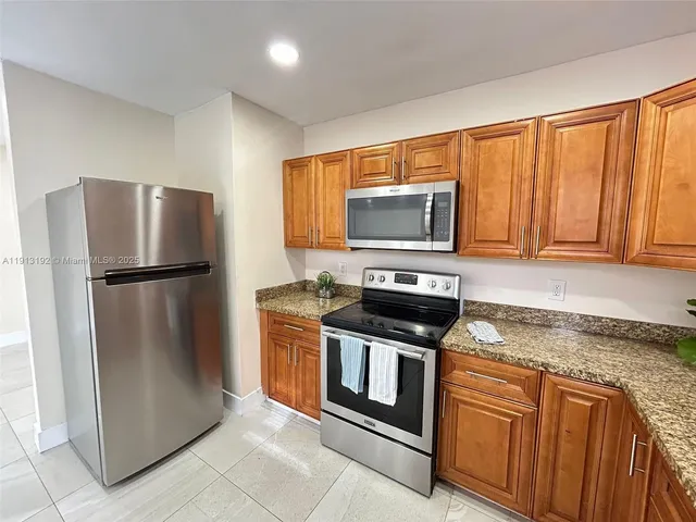 a kitchen with granite countertop a stove top oven sink and cabinets