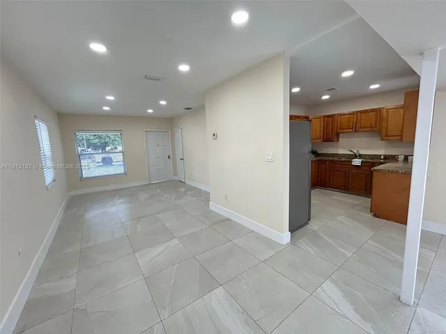 a view of an empty room with a kitchen