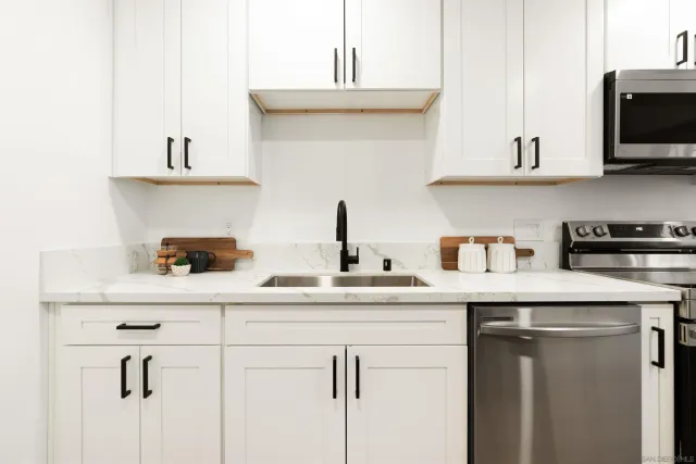 a kitchen with stainless steel appliances a sink a stove and microwave