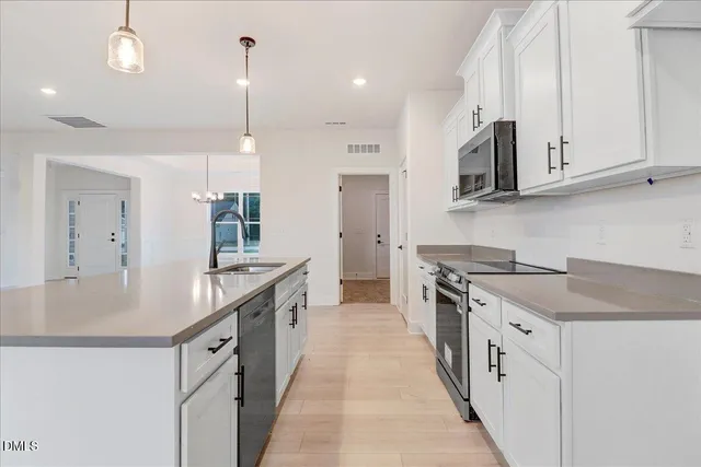 a kitchen with stainless steel appliances a sink a stove and a microwave