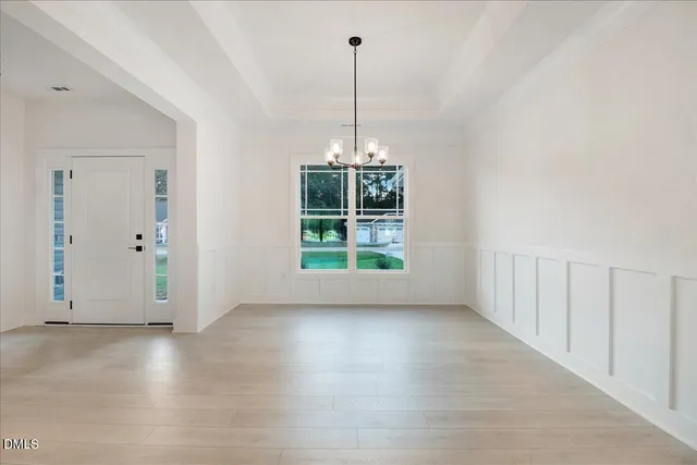 an empty room with windows and a ceiling fan