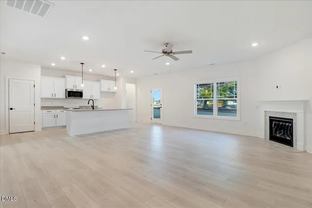 an empty room with windows and fireplace