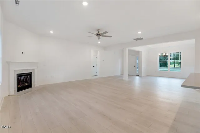 a kitchen with stainless steel appliances kitchen island a sink a stove a refrigerator and white cabinets