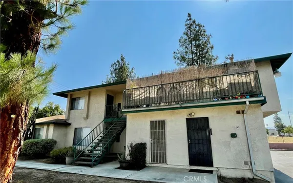 a front view of a house with a tree
