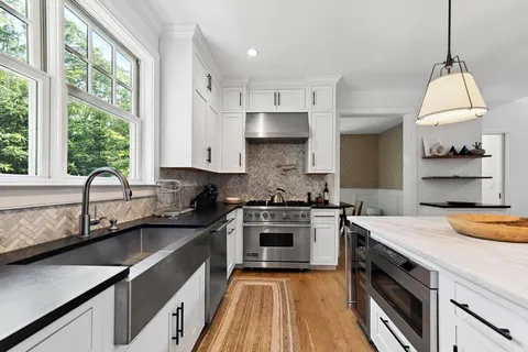 a kitchen with counter top space a sink appliances and cabinets