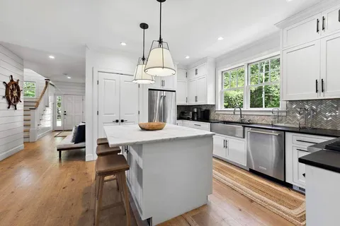 a kitchen with a table chairs and wooden floor