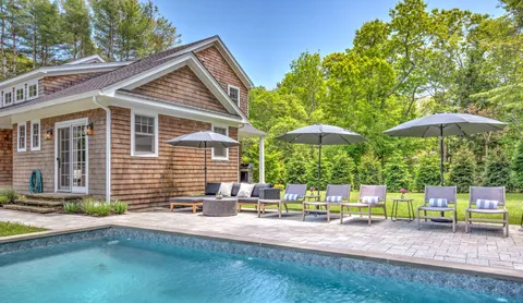 a view of backyard with swimming pool and furniture