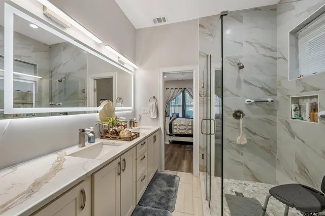a bathroom with a granite countertop sink mirror and shower