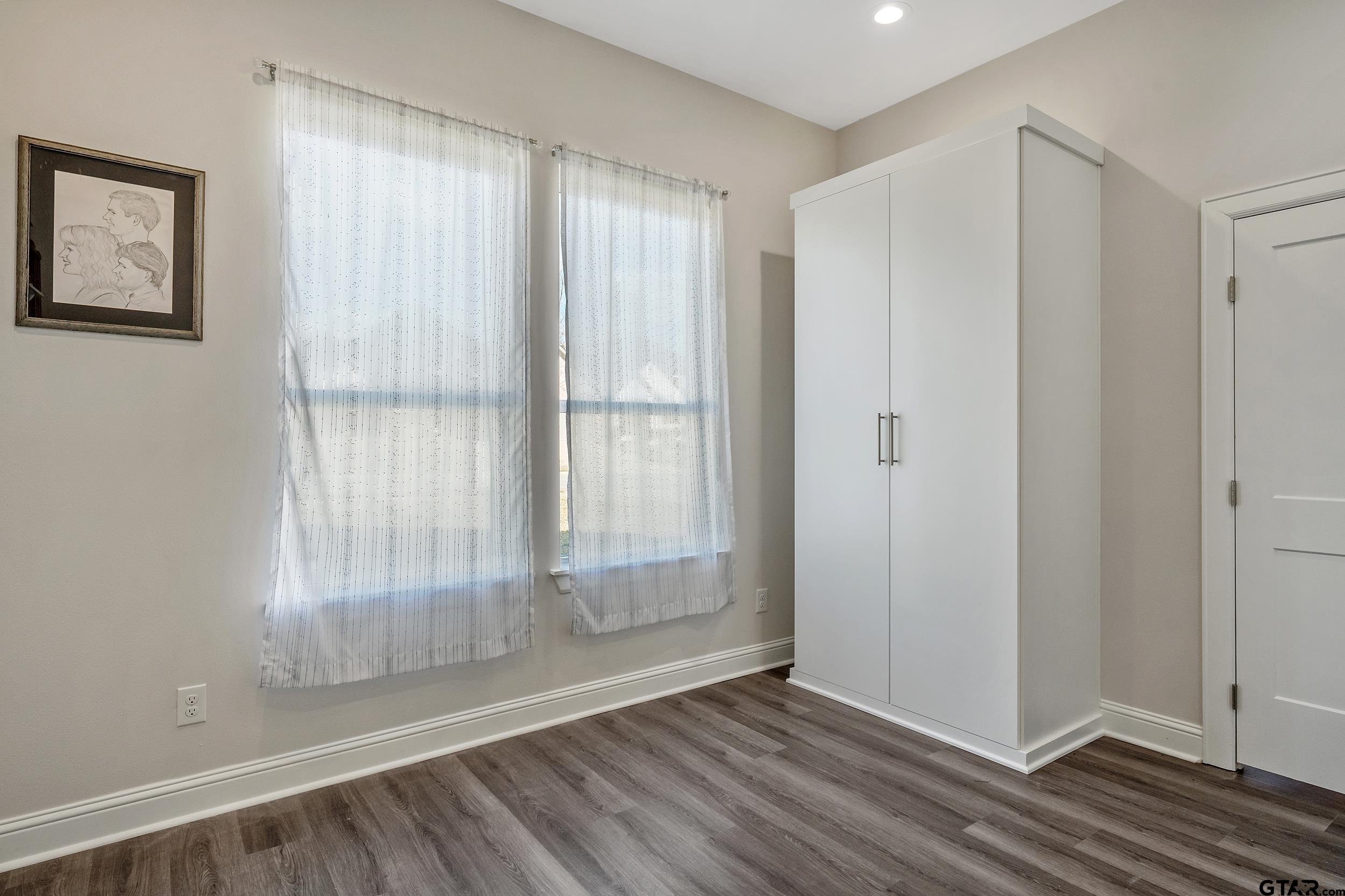 9109 Long Branch Tyler, TX 75703 - Photo 17 of 34 a view of an empty room with wooden floor and a window