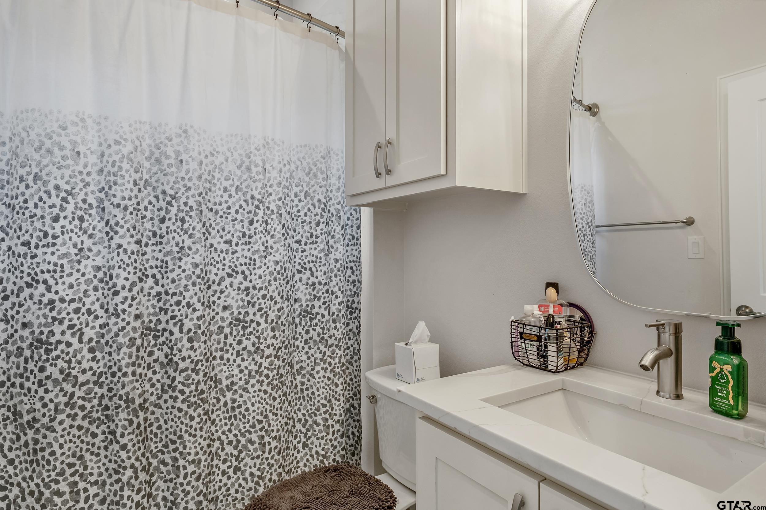 9109 Long Branch Tyler, TX 75703 - Photo 20 of 34 a bathroom with a shower curtain and a sink