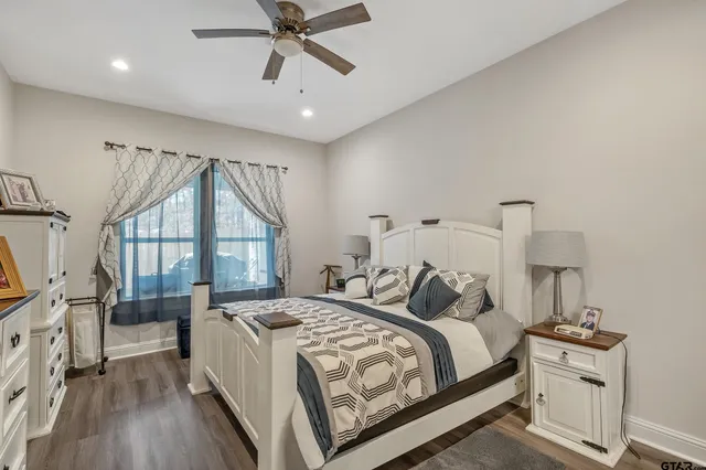 a bedroom with a bed a chandelier and dresser