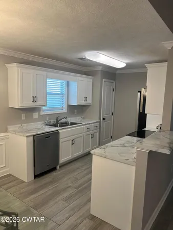 a kitchen with granite countertop white cabinets and white appliances
