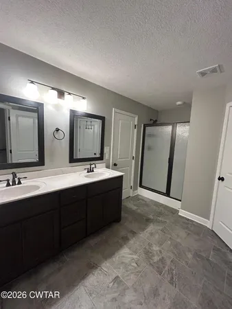 a spacious bathroom with a double vanity sink and a mirror