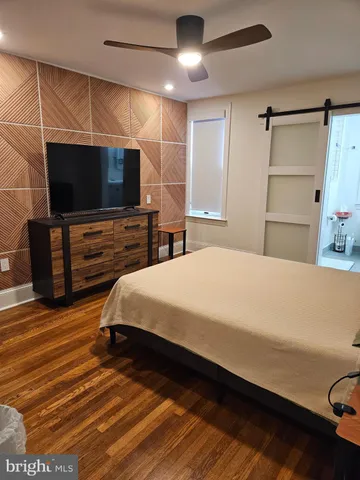 a view of an empty room with furniture and wooden floor