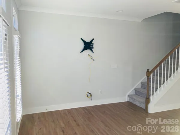 a view of a room with wooden floor and white walls