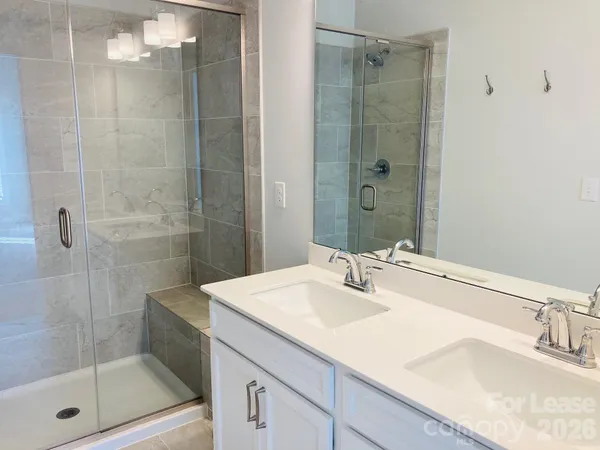 a bathroom with a shower sink and mirror