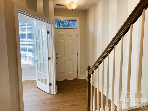 a view of a hallway with wooden floor and staircase