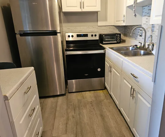 a kitchen with a refrigerator sink stove and cabinets