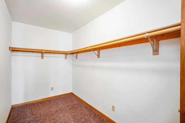 an empty room with windows and ceiling fan