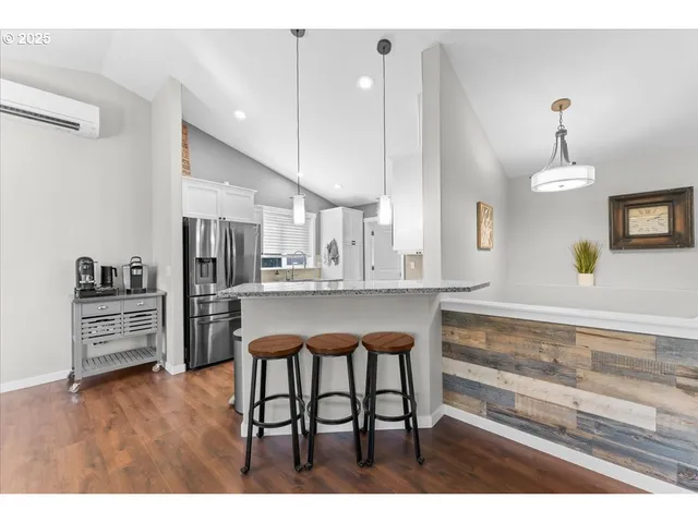 a kitchen with stainless steel appliances kitchen island granite countertop a refrigerator and a stove top oven