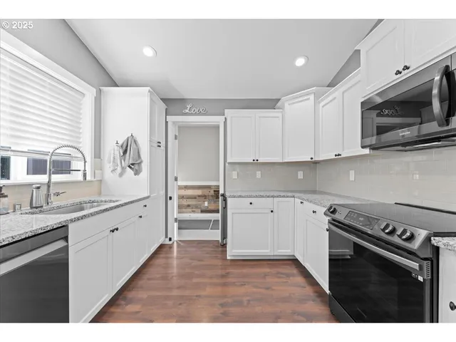 a kitchen with stainless steel appliances granite countertop a stove a sink and a microwave
