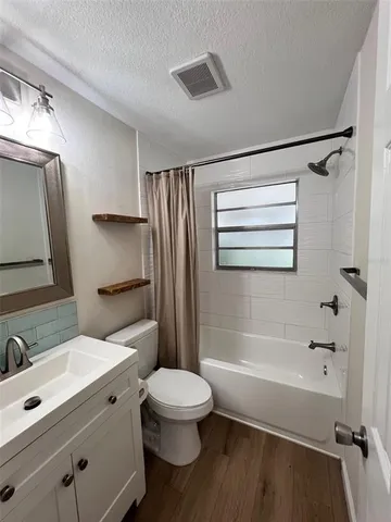 a bathroom with a sink a toilet a mirror and shower
