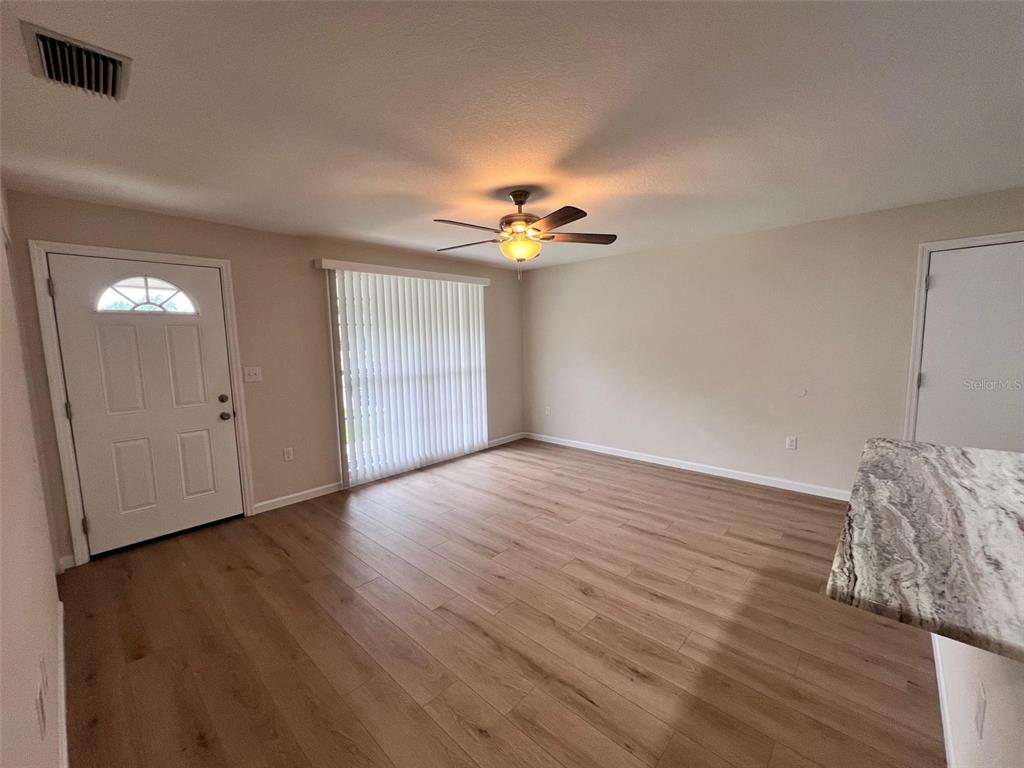 7020 Wentworth Way New Port Richey, FL 34655 - Photo 2 of 22 a view of a room with wooden floor and a ceiling fan