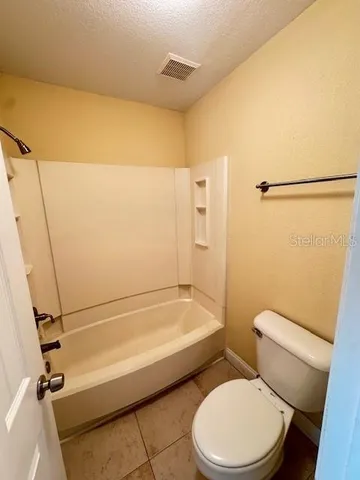 a white toilet and tub sitting next to a bathroom sink