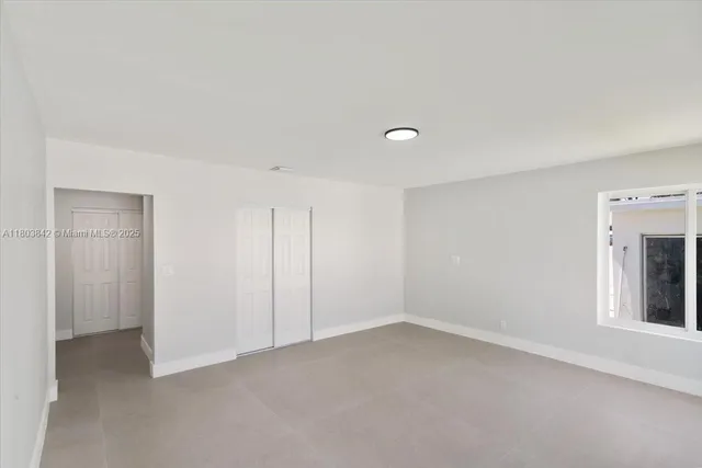 an empty room with windows and closet