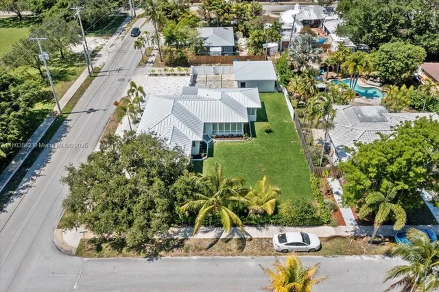 an aerial view of a house with a yard potted plants and large trees