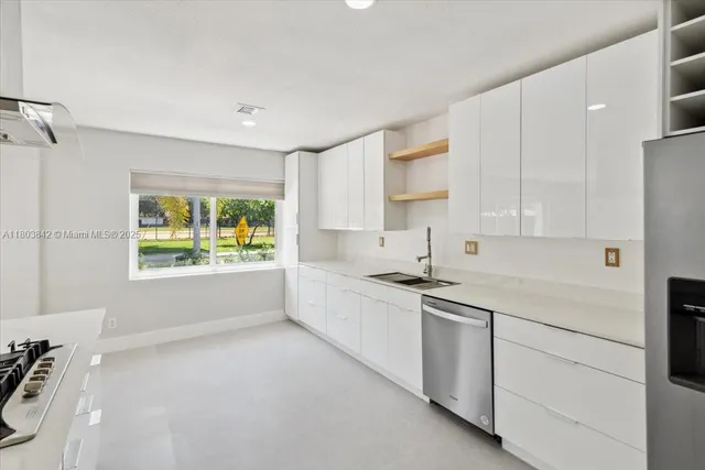 a kitchen with granite countertop white cabinets and white appliances