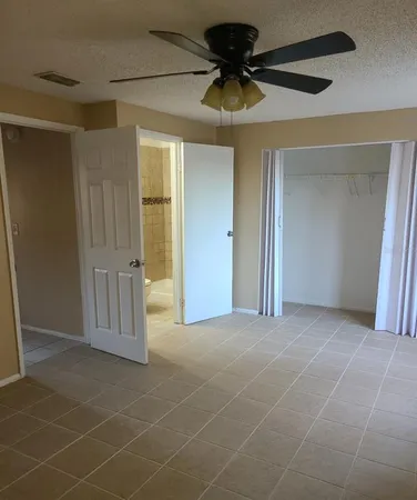 a view of a livingroom with a chandelier fan and a hallway