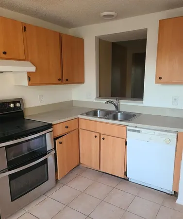 a kitchen with granite countertop white cabinets and stainless steel appliances
