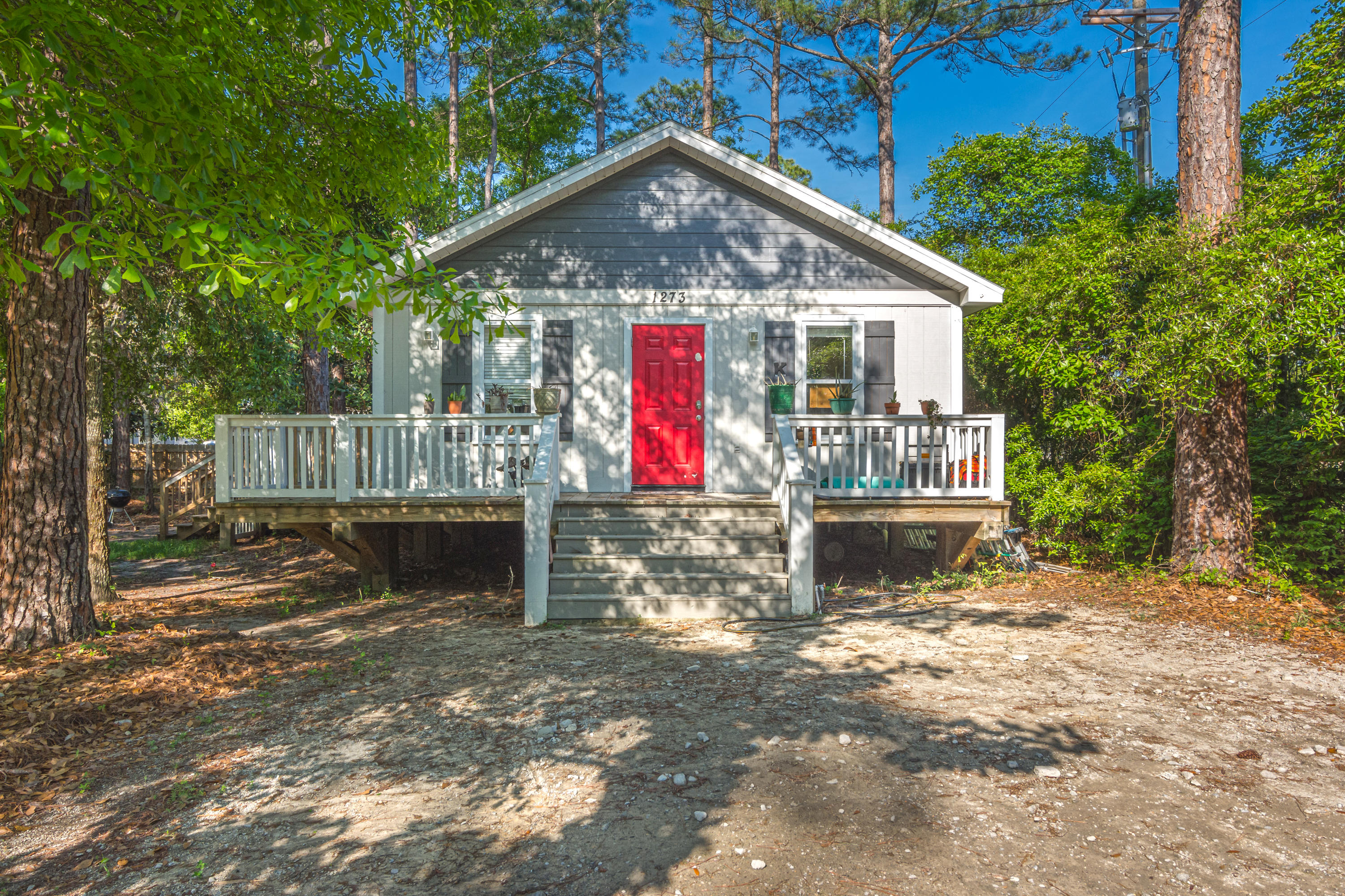 1273 Indian Woman Road Santa Rosa Beach, FL 32459 - Photo 1 of 4 a front view of a house with a yard table and chairs