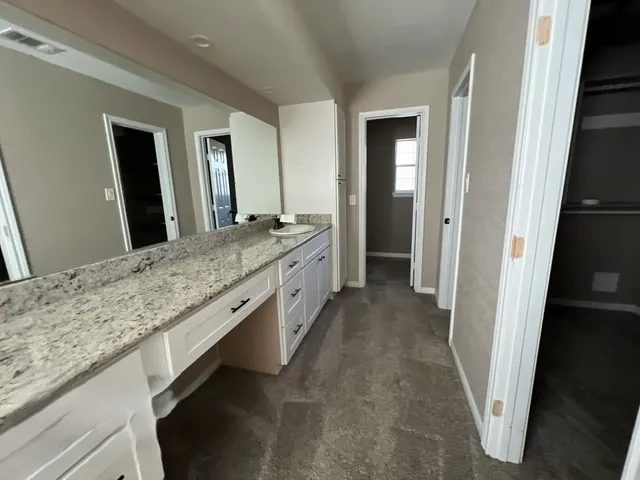 a bathroom with a granite countertop sink and a mirror