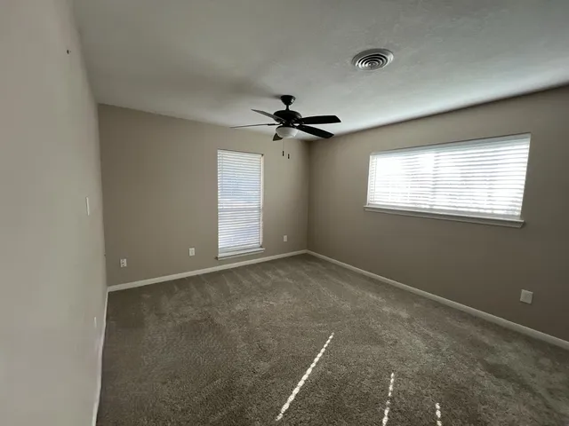 a view of a livingroom with a ceiling fan and window
