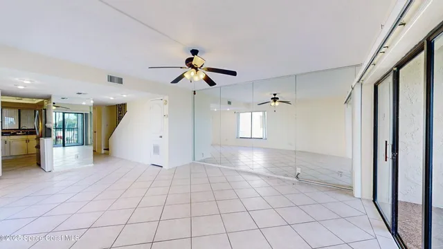 a view of a hallway with wooden floor and a ceiling fan