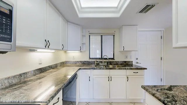 a kitchen with granite countertop a sink and a stove