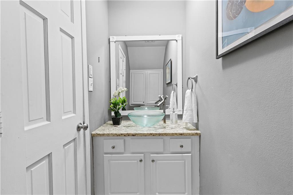 1101 Collier Road Northwest, Unit D5 Atlanta, GA 30318 - Photo 11 of 38 a bathroom with a granite countertop sink and a mirror