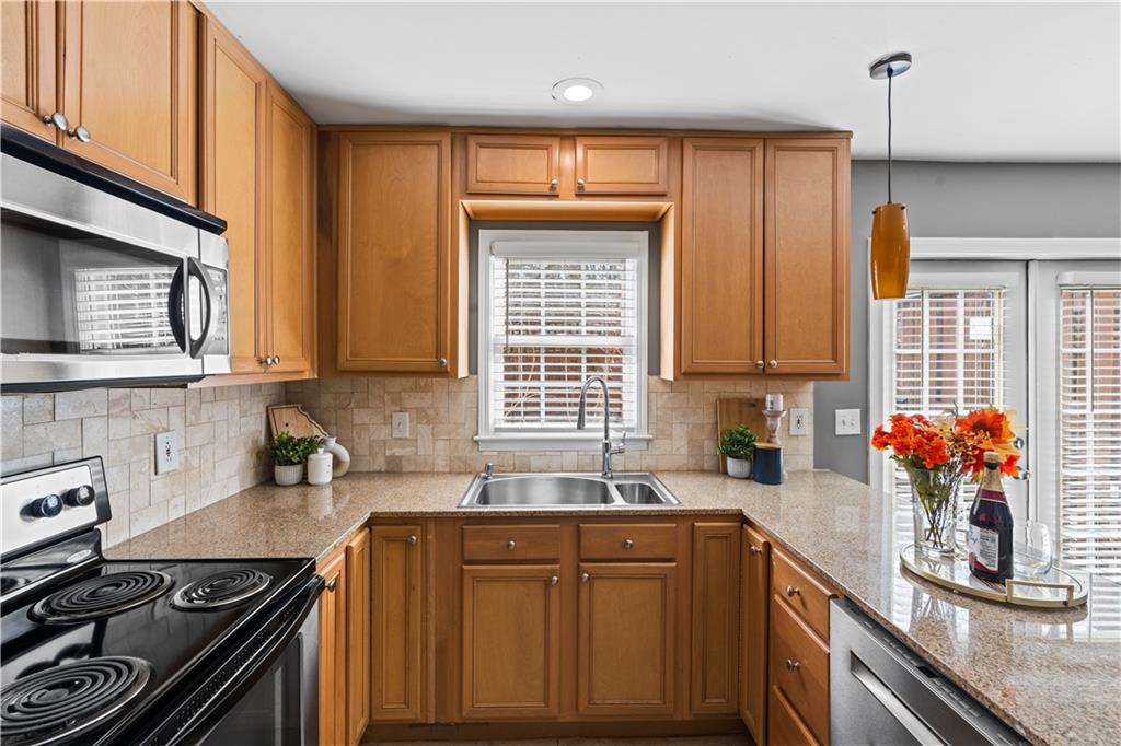 1101 Collier Road Northwest, Unit D5 Atlanta, GA 30318 - Photo 3 of 38 a kitchen with stainless steel appliances granite countertop a sink stove and cabinets