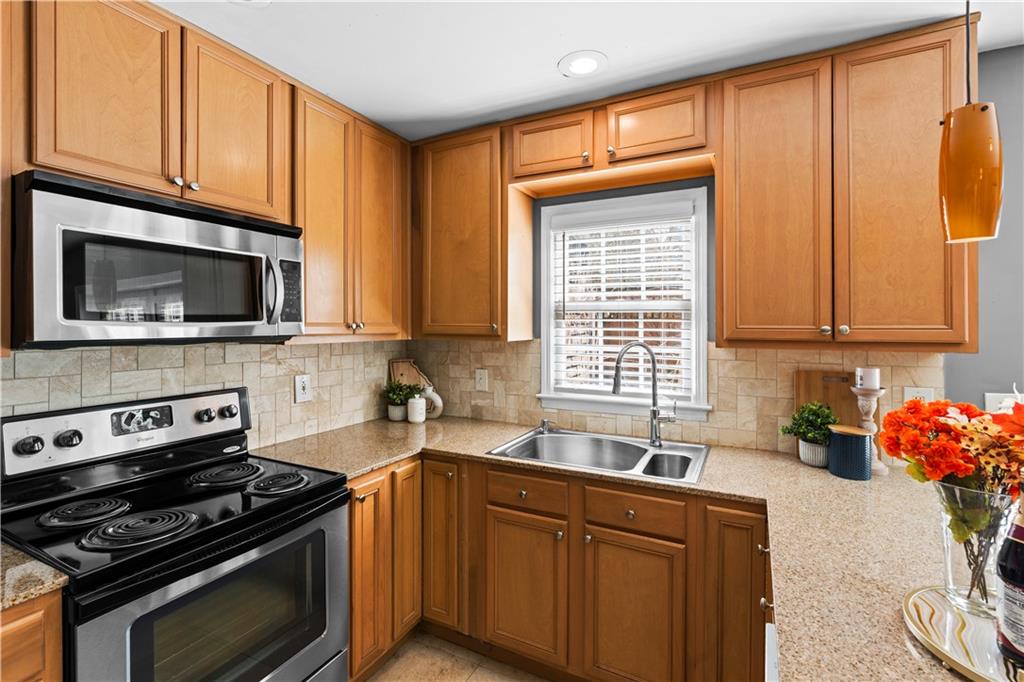 1101 Collier Road Northwest, Unit D5 Atlanta, GA 30318 - Photo 4 of 38 a kitchen with stainless steel appliances a stove a sink and a microwave