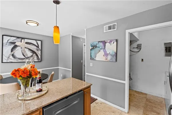 a kitchen with stainless steel appliances granite countertop a dining table chairs and a refrigerator