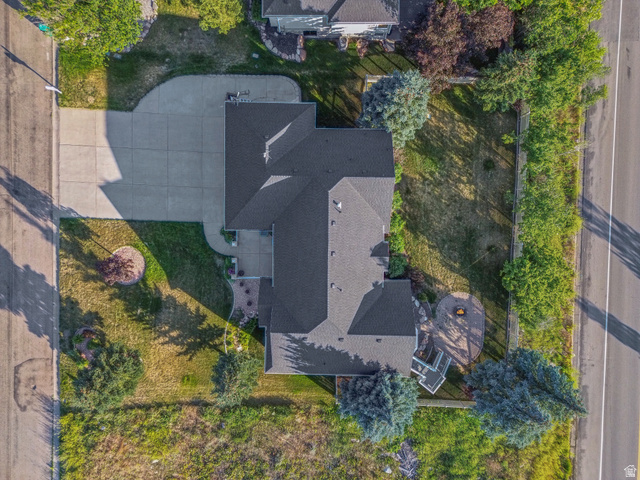 4117 North Wolf Ridge Circle Eden, UT 84310 - Photo 61 of 63 Spacious property featuring a large concrete driveway, mature trees, and a private rear patio with a built-in fire pit