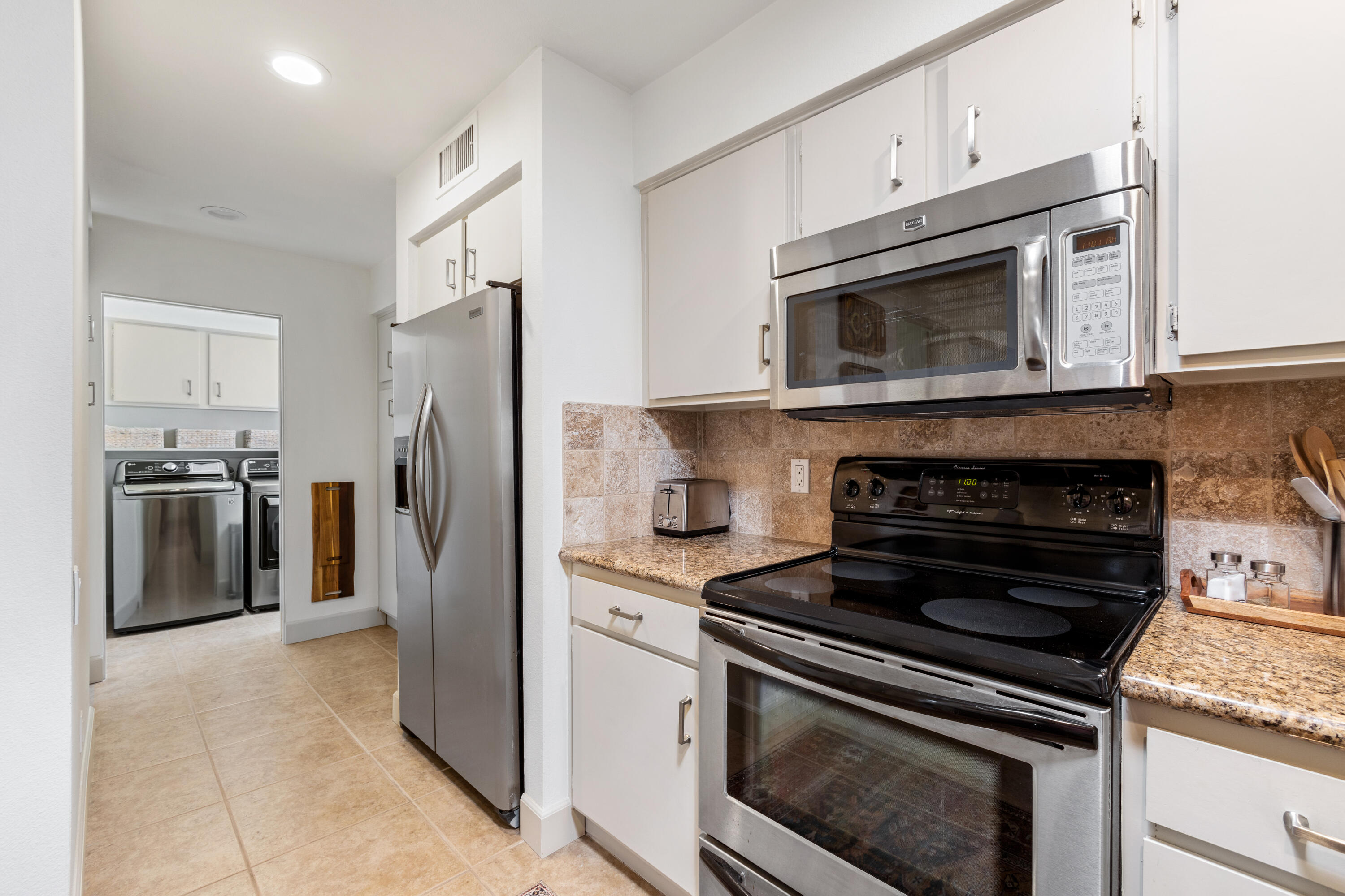 303 Forest Hills Drive Rancho Mirage, CA 92270 - Photo 32 of 72 a kitchen with cabinets and stainless steel appliances