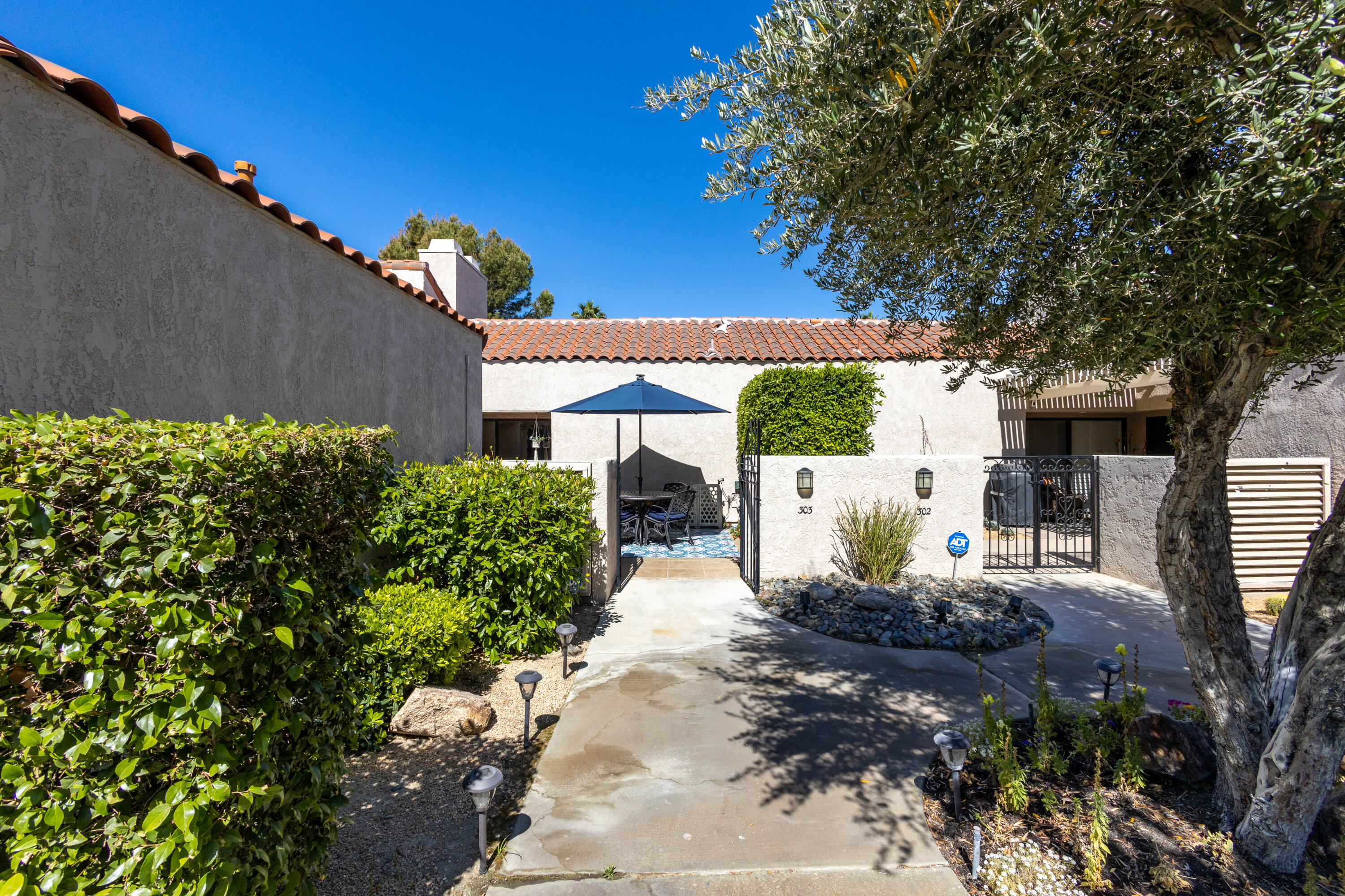 303 Forest Hills Drive Rancho Mirage, CA 92270 - Photo 4 of 72 a front view of a house with garden
