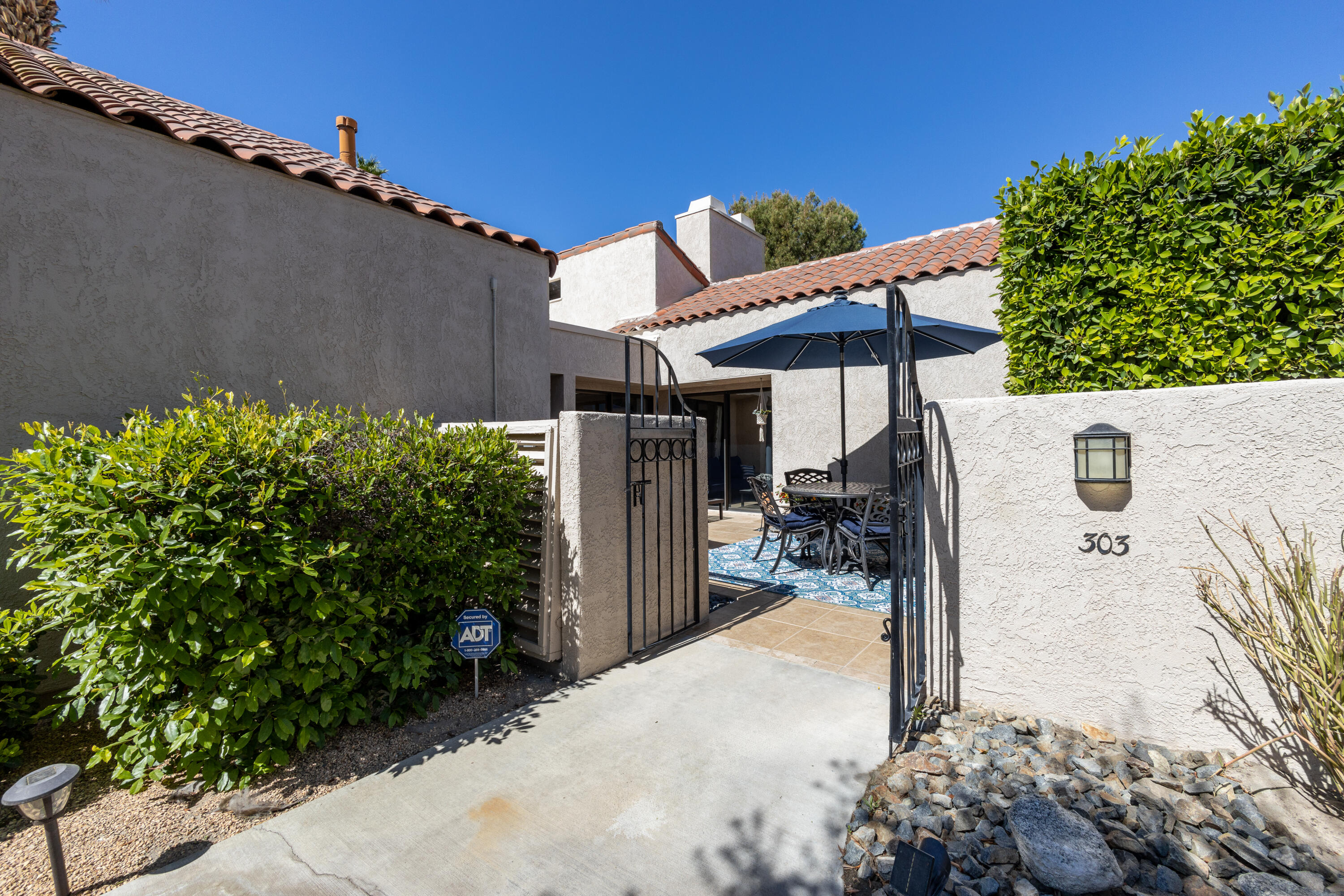303 Forest Hills Drive Rancho Mirage, CA 92270 - Photo 5 of 72 a view of a patio with a table and chairs under an umbrella