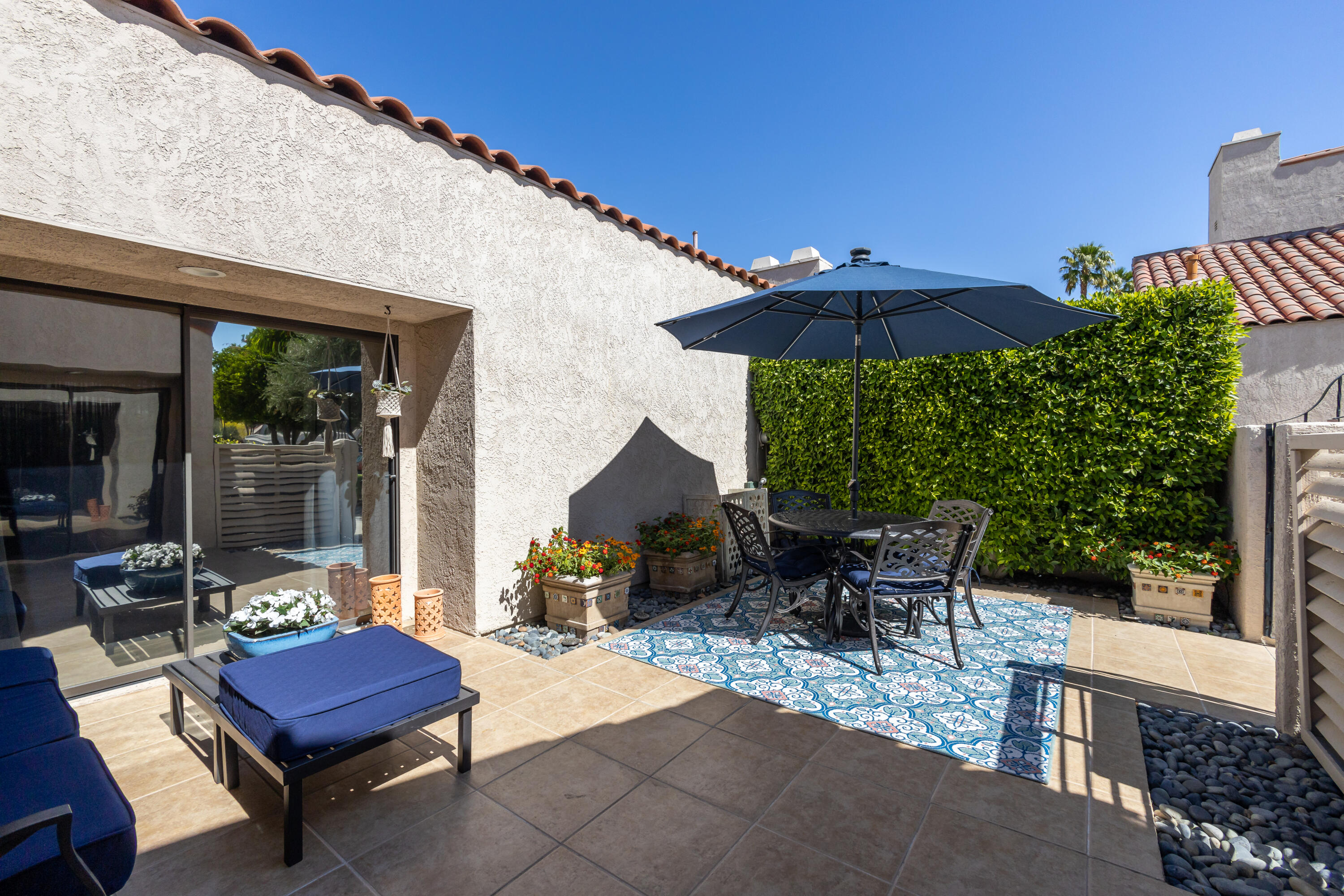 303 Forest Hills Drive Rancho Mirage, CA 92270 - Photo 7 of 72 a view of a patio with a table and chairs under an umbrella