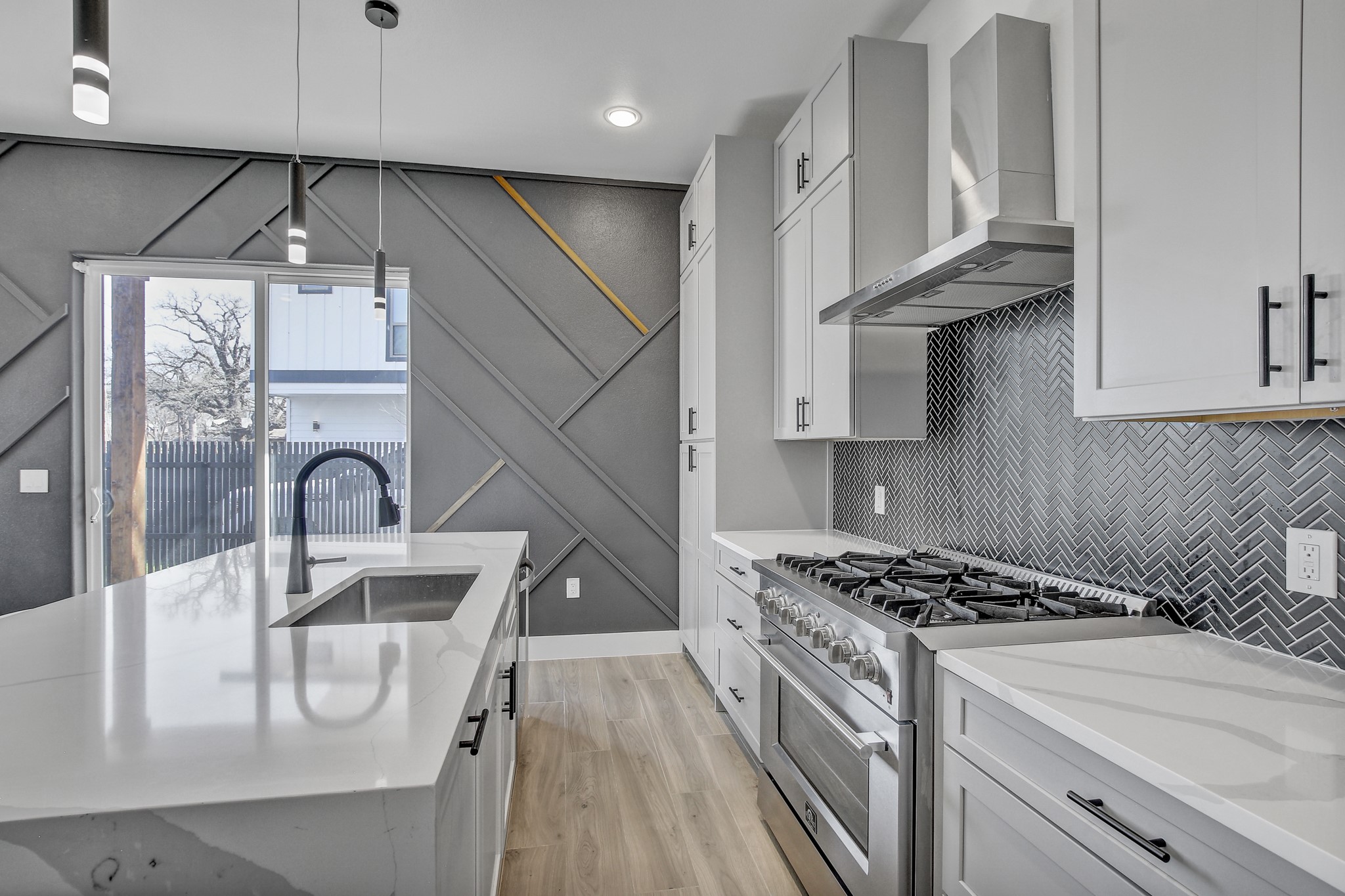 4703 Louis Avenue, Unit A Austin, TX 78721 - Photo 13 of 35 Kitchen with high end stainless steel range, light stone countertops, pendant lighting, light wood-type flooring, and white cabinetry