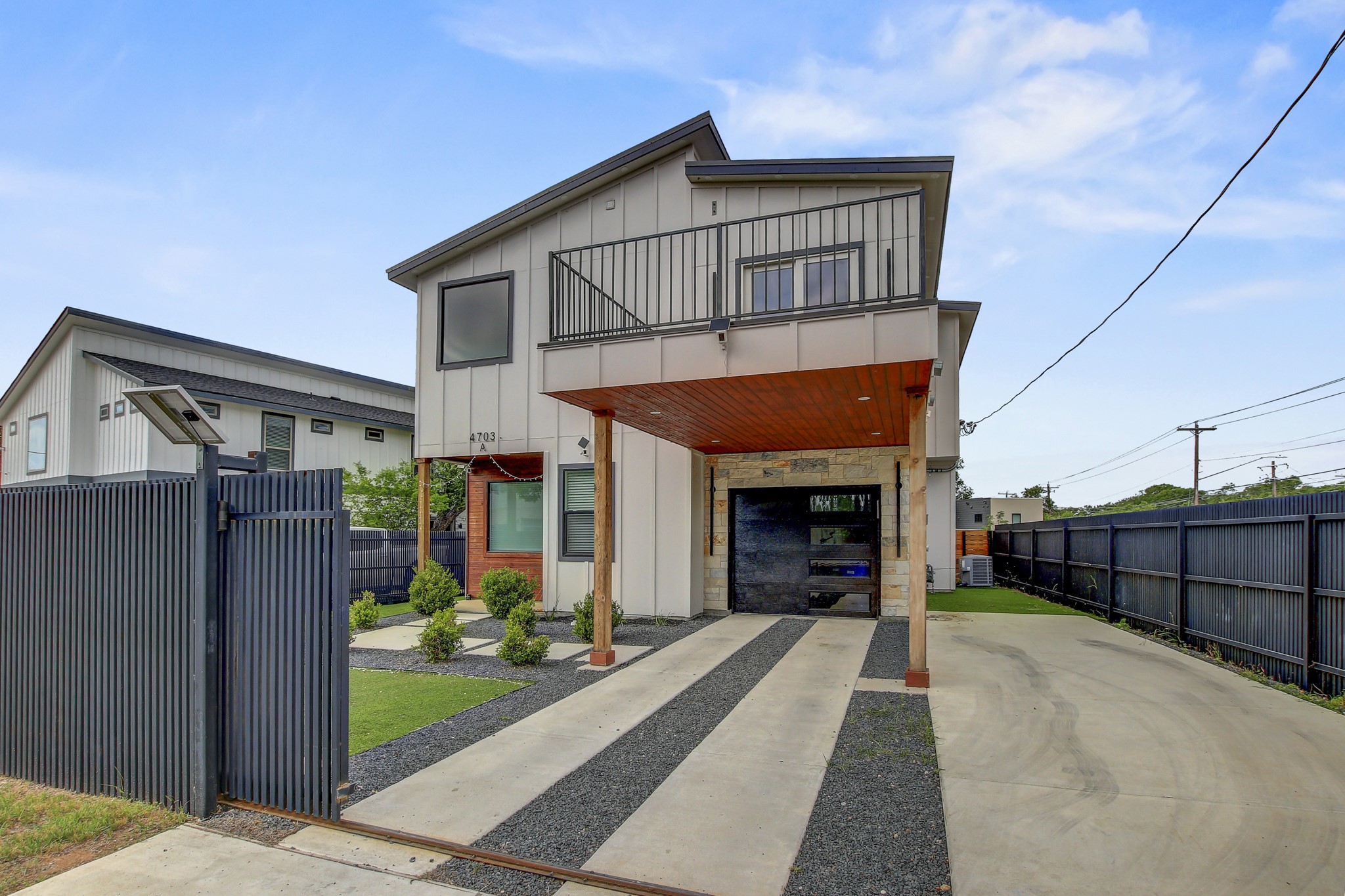 4703 Louis Avenue, Unit A Austin, TX 78721 - Photo 2 of 35 Contemporary home featuring board and batten siding, driveway, an attached garage, and a balcony