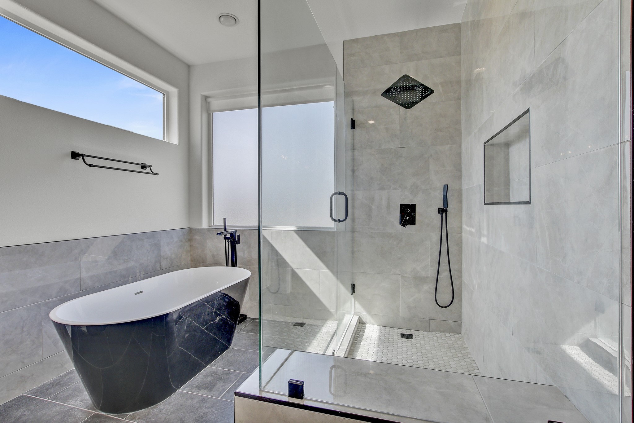 4703 Louis Avenue, Unit A Austin, TX 78721 - Photo 22 of 35 Full bathroom with a stall shower, a freestanding bath, tile walls, and tile patterned flooring